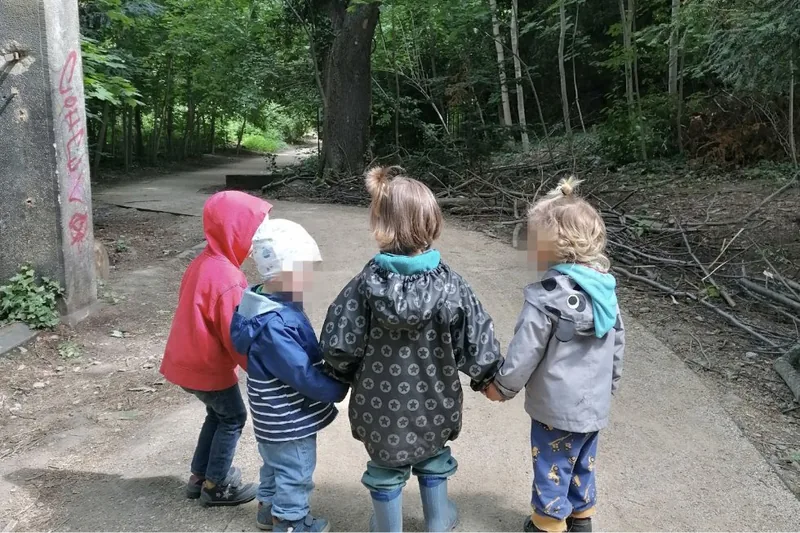 Kinder der Kindertagespflege Am Bienertpark halten sich bei einem gemeinsamen Ausflug liebevoll an den Händen